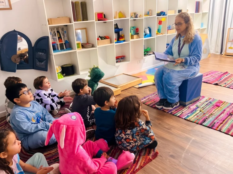 Professora conversa com crianças da Educação Infantil sentadas no tapete da sala