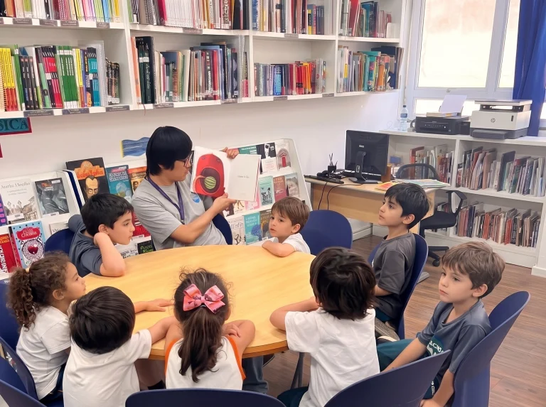 Alunos leem em uma mesa redonda na biblioteca do colégio