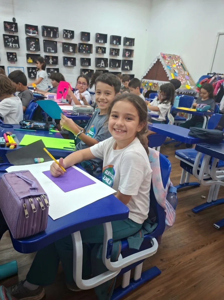 Aluna do Fundamental I sorri na carteira durante a aula