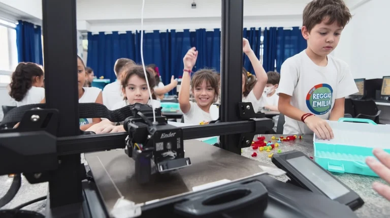 Alunos acompanham a impressora 3D na aula de robótica